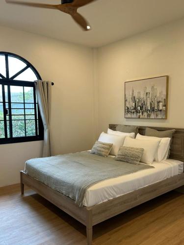 a bed in a bedroom with a ceiling fan at Chalong Home Phuket in Phuket