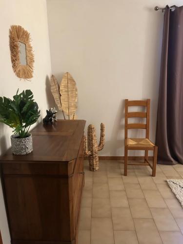 a living room with a table and a chair at Maison 6 personnes avec piscine terrain arboré clôturé in Vallabrix