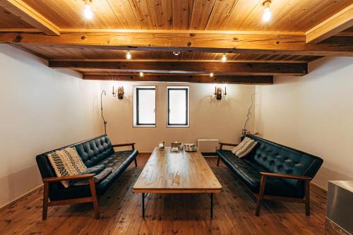 a room with couches and a table in a room at サウナ付き一棟貸し宿 大岡辻-tsuji oooka- in Ookanakamaki