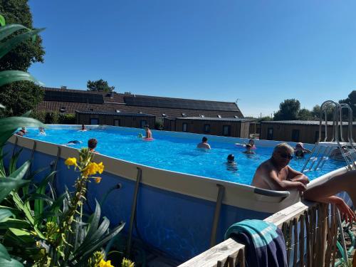 a group of people swimming in a swimming pool at Mobil home neuf à étaples à 5 minutes du touquet in Étaples