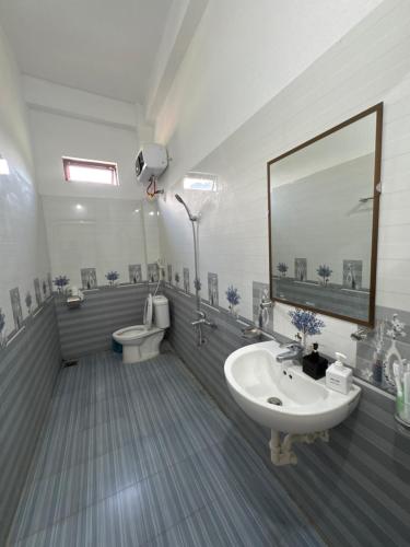a bathroom with a sink and a toilet and a mirror at Ba Be Lake - Nhà Nghỉ Thư Nhạc in Bak Kan