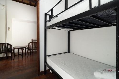 a room with two bunk beds and a table at Tricky Trees Lodges in Gili Air