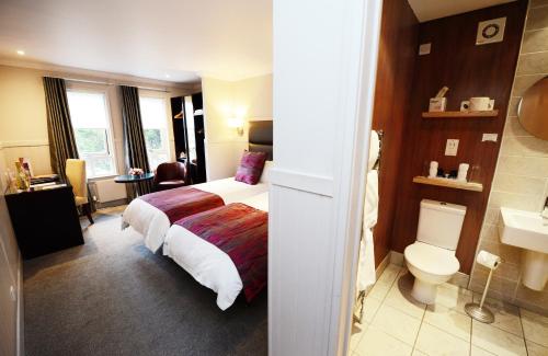 a hotel room with a bed and a toilet at Glynhill Hotel & Spa near Glasgow Airport in Paisley