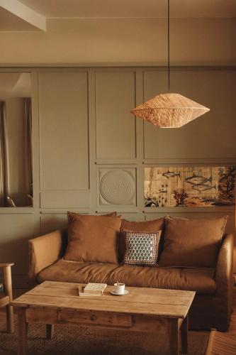 a living room with a brown couch and a table at Hôtel BelleVue in Bréhat