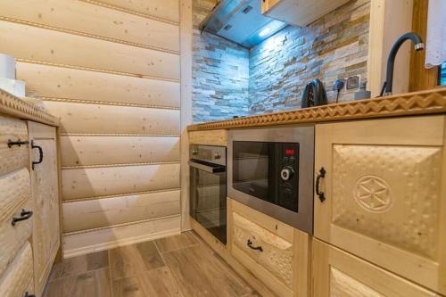 a kitchen with wooden cabinets and a stove at Góralska Kryjówka in Zakopane
