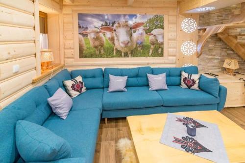 a blue couch in a living room with a picture of cows at Góralska Kryjówka in Zakopane