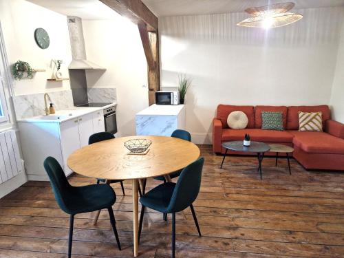 a living room with a table and a couch at Charmant T2 avec Loggia vue montagne in Laruns
