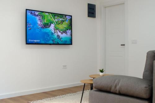 a living room with a tv hanging on a wall at Harasani apartments in Ulcinj