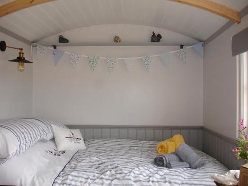 a bedroom with a bed with a banner on the wall at Apple Tree Shepherd's Huts - Blackberry Hut in Saint Endellion