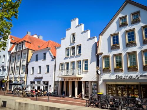 a group of buildings on a street with tables and chairs at Markt22 - Exklusive Stadtapartments in Lingen