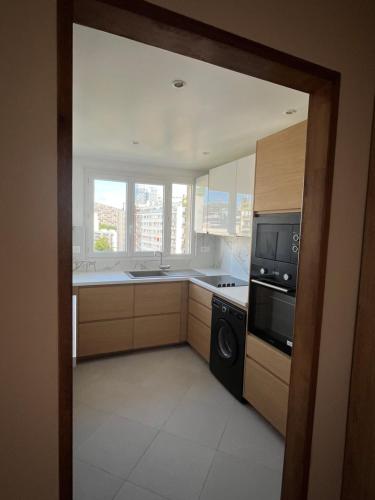 a kitchen with a stove and a microwave at Very luxurious apartment in Paris - 10 min de la tour eiffel in Boulogne-Billancourt