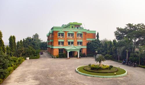 a large brick building with a courtyard in front of it at Lumbini Zambala Hotel in Lumbini