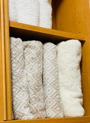 a group of white towels on a shelf at Warm family stay ーEasy Access Kyoto & Osaka ー in Takatuki