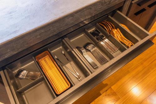 a kitchen drawer with dishes and utensils in it at Villa Yamagara with lake view in Fujikawaguchiko