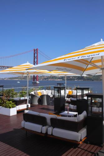 a deck with couches and tables under a canopy at Hyatt Regency Lisbon in Lisbon