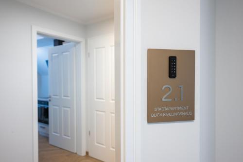 a sign on a door with a remote control on it at Markt22 - Exklusive Stadtapartments in Lingen