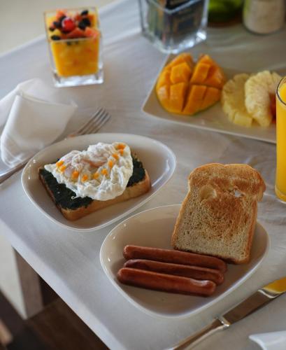 un tavolo con due piatti di cibo con uova e salsiccia di Amani Villas Nature Retreat a Michamvi Kae