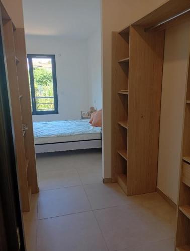 Cette chambre comprend un lit et un placard avec une fenêtre. dans l'établissement Charmante villa neuve au bord de la plage, à Saint-Raphaël