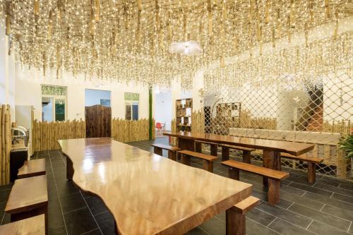 a room with wooden tables and a bunch of chandeliers at Sanya Yalong Bay Zhenghe Jingmei Hostel - Free Public Kitchen in Sanya