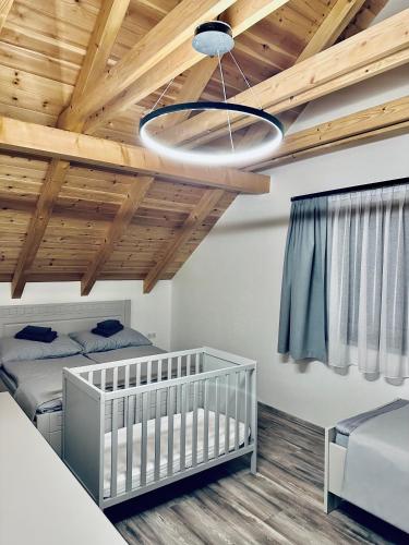 a bedroom with two twin beds and a ceiling with wood at Wellness chata pod Orechom in Dolná Lehota