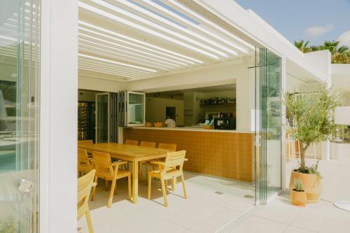 an open kitchen and dining room with a wooden table and chairs at Ses Eufabietes Apartments & Restaurant in Sant Francesc Xavier