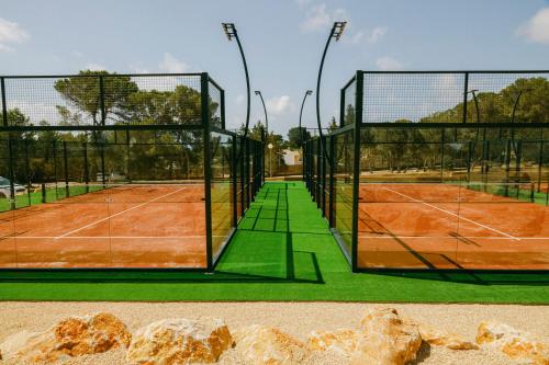 a tennis court with two tennis courts at Ses Eufabietes Apartments & Restaurant in Sant Francesc Xavier
