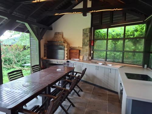 een keuken met een houten tafel en een aantal ramen bij Vilele Lucia in Sinaia