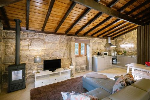 a living room with a couch and a tv and a kitchen at Encosta Dos Túneis - Turismo E Lazer in Sever do Vouga