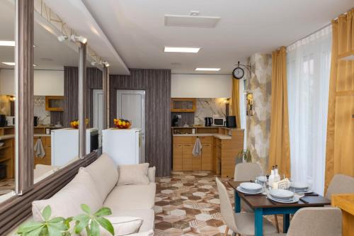 a living room with a white couch and a kitchen at Good Mood Apartments & Parking in Plovdiv