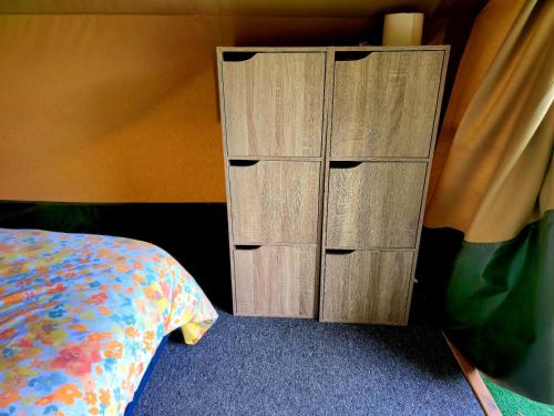 a wooden cabinet with four drawers next to a bed at GITES O FIL DE L'EAU piscine spa accès rivière in Omessa