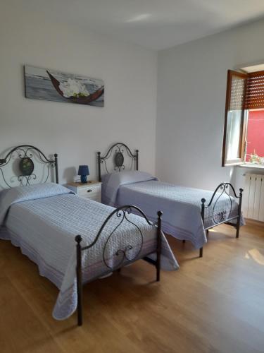 a bedroom with two beds and a window at alloggio turistico olmata in Montevirginio