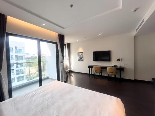une chambre avec un lit, un bureau et une télévision dans l'établissement Sky View Homestay, à Hạ Long
