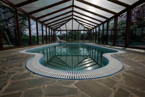 a swimming pool in a building with a roof at Chata pod Radhoštěm in Trojanovice