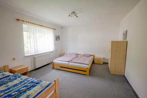 a bedroom with two beds and a window at Chata pod Radhoštěm in Trojanovice