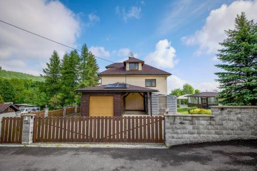 a house with a fence and a gate at Chata pod Radhoštěm in Trojanovice