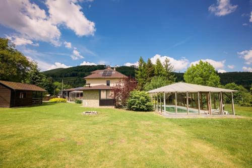 a yard with a gazebo and a house at Chata pod Radhoštěm in Trojanovice