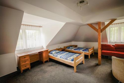 a attic room with two beds and a couch at Chata pod Radhoštěm in Trojanovice
