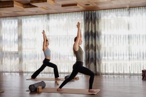 two women doing a yoga pose in a yoga class at Rieser Achensee Resort in Pertisau