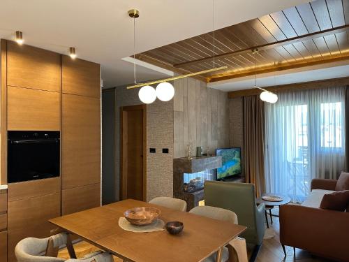 a living room with a dining table and a kitchen at Apartment MonteBreza Spa in Kolašin