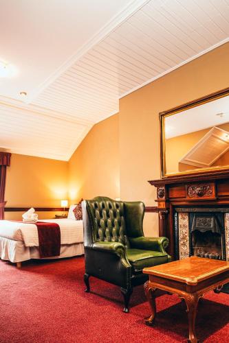 a bedroom with a bed and a chair and a mirror at Russell Court Hotel in Dublin