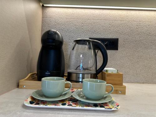 two cups on a tray next to a coffee maker at Apartment MonteBreza Spa in Kolašin