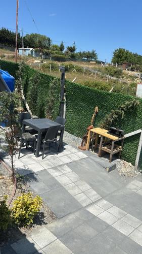 a patio with a table and chairs and a bench at Karahan bungalov in Tayakadın