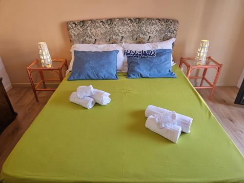 a green bed with towels on top of it at Zafferana Etna House by Holiday World in Zafferana Etnea