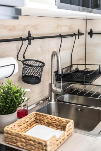 a kitchen sink with a faucet and a basket at MAGDAROSA Resort in Harkány