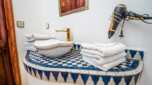 un bagno con lavandino e asciugamani su un bancone di Riad le dromadaire bleu by Weekome a Marrakech