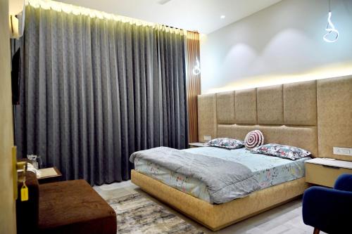 a bedroom with a bed and a large window at Ista Inn Homestay in Amritsar