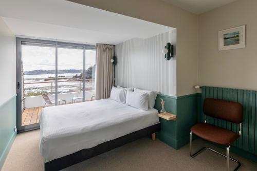 a hotel room with a bed and a balcony at Hôtel BelleVue in Bréhat