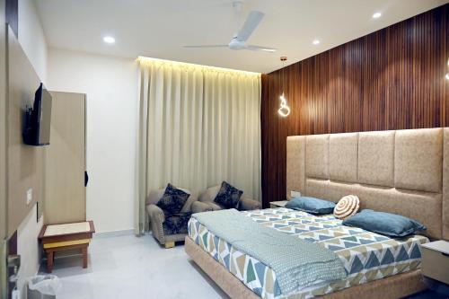 a bedroom with a large bed and a chair at Ista Inn Homestay in Amritsar