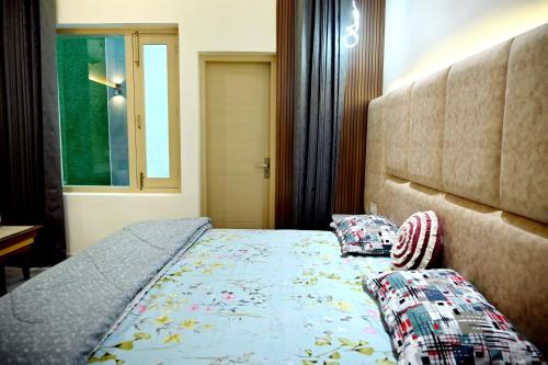 a bedroom with a bed with two pillows on it at Ista Inn Homestay in Amritsar