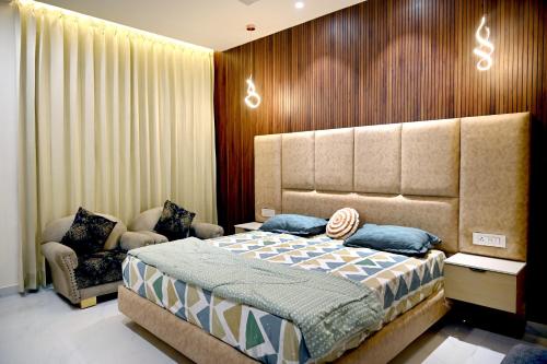 a bedroom with a large bed and a chair at Ista Inn Homestay in Amritsar